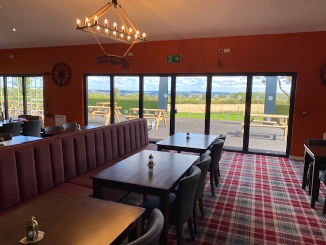 Interior with wagon-wheel chandelier and panoramic countryside views